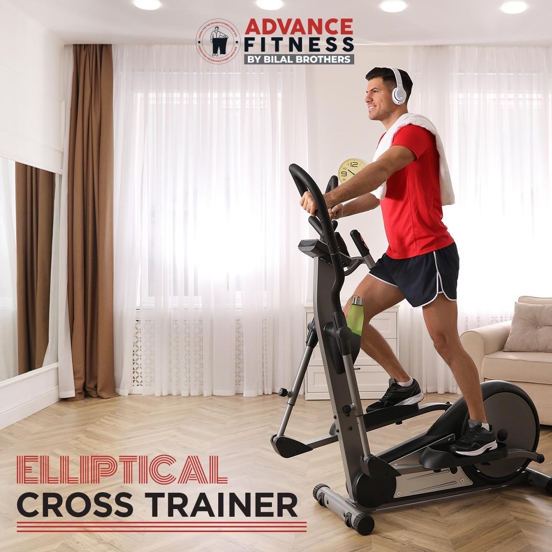 A man on a elliptical cross trainer in a room.